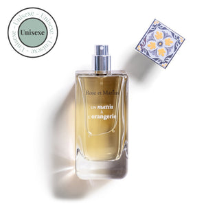 A bottle of ROSE ET MARIUS - A MORNING AT THE ORANGERY EAU DE PARFUM 30ML with a decorative square cap stands beside a circular "Unisexe" label in the top left. The bottle casts a faint shadow on a white background.