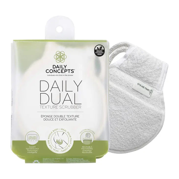 The packaging and product of the DAILY CONCEPTS DUAL TEXTURE SCRUBBER emphasize its ability to provide a gentle cleanse and mild exfoliation for skincare. Key benefits such as gentle cleansing, exfoliation, and smart technology for product writing are highlighted on the packaging, with the scrubber visible through it.
