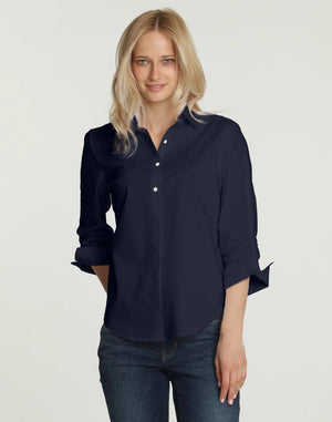 A person wearing the HINSON WU - ZOEY SHIRT in black, with the sleeves rolled up and paired with blue jeans. The image highlights the classic tailored design from shoulders down against a plain white background.