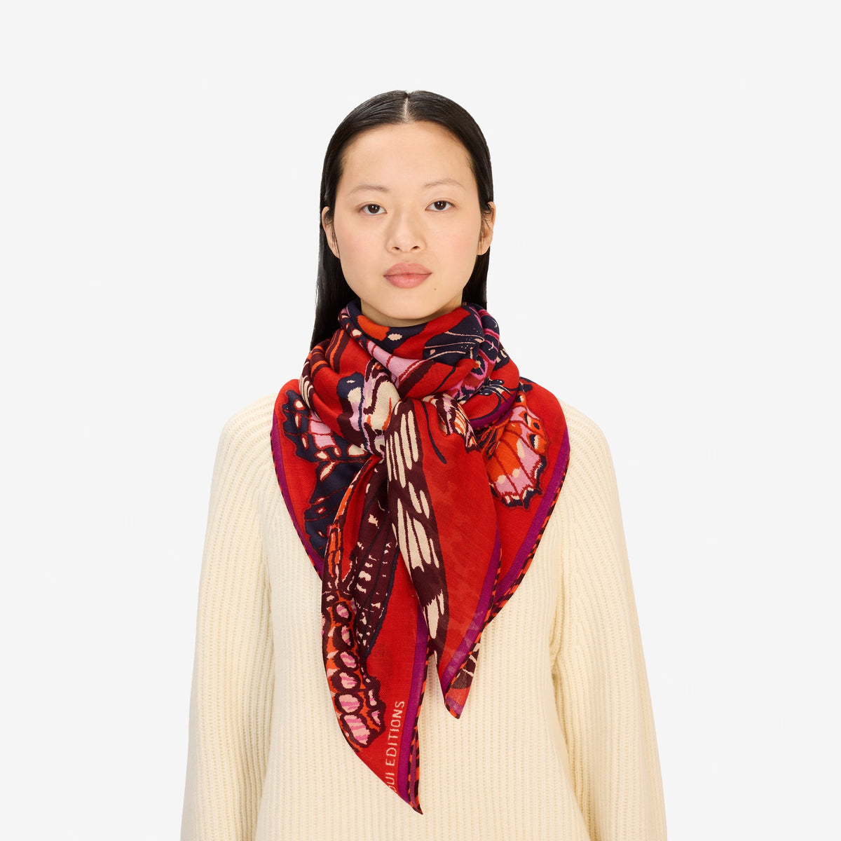 The INOUI EDITIONS PAPILLONS Square Wool Scarf in red features colorful butterflies in pink, orange, purple, and brown across a vibrant 130x130cm design—an eye-catching and versatile accessory for any occasion.