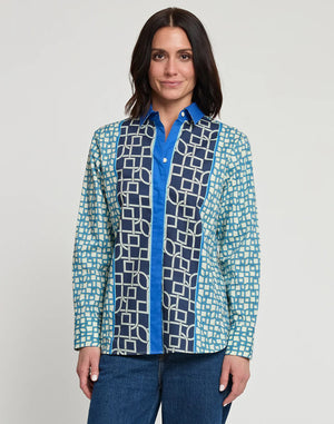 A person with shoulder-length dark hair is standing with their back to the camera, wearing a relaxed-fit HINSON WU - MARGOT LONG SLEEVE MAZE GEO PRINT SHIRT and blue jeans. The background is plain white.