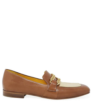 The FLAT TWO TONE LOAFER WITH CHAIN by MADISON MAISON is a stylish flat loafer crafted from the finest leathers. It features a light beige vamp adorned with two gold chain embellishments on the upper. Designed for maximum comfort, this brown leather beauty boasts a classic slip-on design and a low heel.