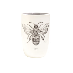 A set of four Creative Co-op stoneware tumblers, each adorned with black and white illustrations of a butterfly, dragonfly, ladybug, and bee, stand side by side against a pristine white backdrop.