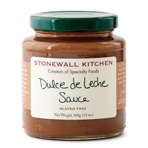 A jar of STONEWALL KITCHEN - DULCE DE LECHE SAUCE is shown. The label describes it as gluten-free, weighing 369 grams (13 oz), and it is renowned for its specialty foods. Perfect for baking, the jar has a green lid, and the sauce inside appears caramel-colored.