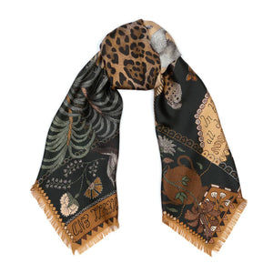 The SABINA SAVAGE ENGLAND - THE JAGUAR'S PARADISE SILK TWILL 135CM scarf showcases an array of nature-inspired illustrations and patterns. It features a stunning mix of animal prints, including a detailed leopard pattern, alongside exquisite botanical designs. Highlighting endangered species, the scarf boasts a beige and green color scheme with intricate details reminiscent of an antique embroidery sampler.