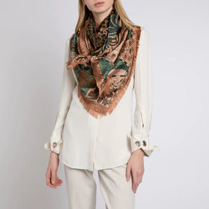 The SABINA SAVAGE ENGLAND - THE JAGUAR'S PARADISE SILK TWILL 135CM scarf showcases an array of nature-inspired illustrations and patterns. It features a stunning mix of animal prints, including a detailed leopard pattern, alongside exquisite botanical designs. Highlighting endangered species, the scarf boasts a beige and green color scheme with intricate details reminiscent of an antique embroidery sampler.