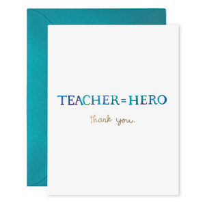 The E. FRANCES - TEACHER EQUALS HERO CARD by E. FRANCES PAPER features the bold message "TEACHER = HERO" in large blue and purple gradient letters with a smaller gold script "thank you." underneath. The card is printed on heavyweight paper, elegantly placed atop a teal envelope against a white background, exuding the signature sophistication of an E. Frances Paper design.