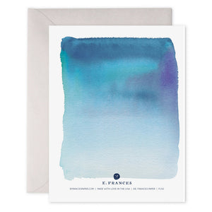 The E. FRANCES - LEAN ON ME CARD by E.FRANCES PAPER showcases a serene scene with a watercolor design in shades of blue and beige. The words "LEAN ON ME" are elegantly printed in gold foil at the center on heavyweight paper, accompanied by a plain light gray envelope.