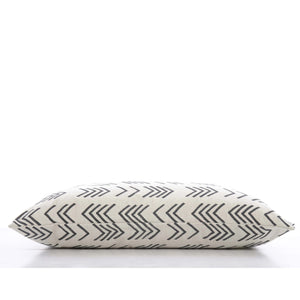 A close-up view of THE FOGGY DOG's DOG BED (S, MODERN MUD CLOTH), showcasing its cream-colored fabric adorned with black, overlapping chevron lines. This boho minimalist dog bed is lying on its side against a plain, white background.