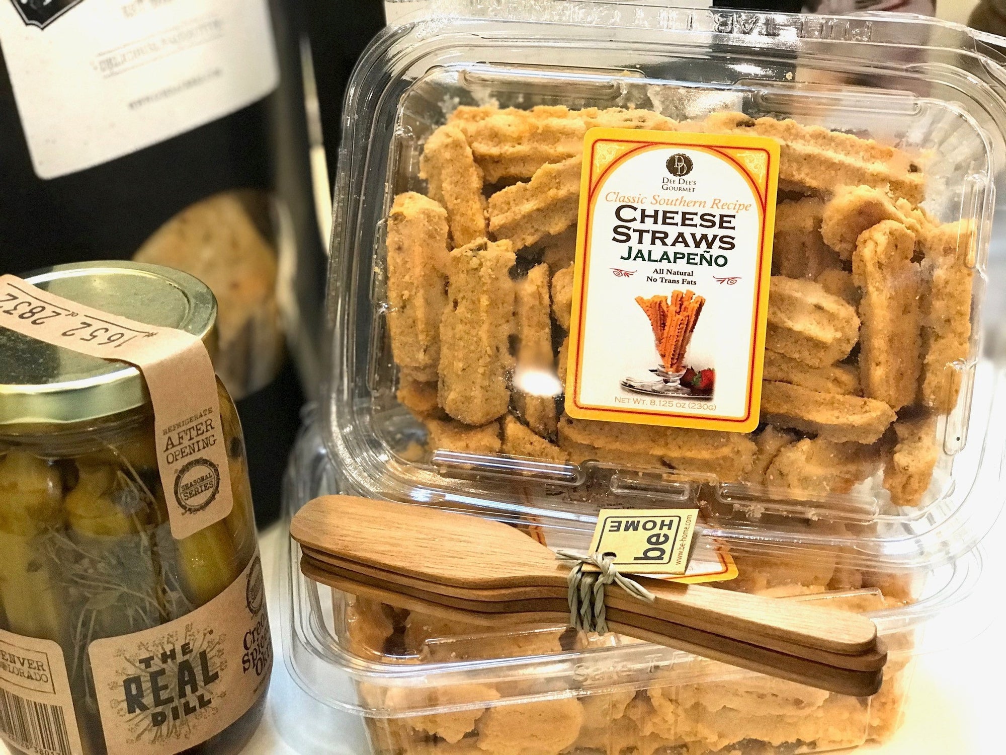 A clear plastic container filled with cheese straws is labeled "DEE DEE'S GOURMET - CHEESE STRAWS Cheddar." The label also mentions "All Natural" and "No Trans Fat." Made with quality ingredients, the container weighs 4.125 oz (117g).