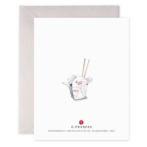 The E. FRANCES - FORTUNE COOKIE CARD, designed by E.FRANCES PAPER, features a minimalistic watercolor painting of a cracked fortune cookie revealing a paper fortune that reads "GOOD LUCK." The card boasts a clean white background printed on luxe heavyweight paper and includes the faint outline of another envelope in the background.