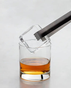 A black and gray box from W&P Design showcases the Peak Clear Ice Mold with a photo of a glass of whiskey being filled with a large, crystal clear ice cube on the front. The box is labeled "Elevate Your Ice," hinting at the premium ice mold inside for colder drinks and slow dilution.