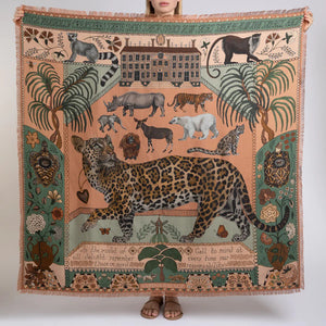 The SABINA SAVAGE ENGLAND - THE JAGUAR'S PARADISE SILK TWILL 135CM scarf showcases an array of nature-inspired illustrations and patterns. It features a stunning mix of animal prints, including a detailed leopard pattern, alongside exquisite botanical designs. Highlighting endangered species, the scarf boasts a beige and green color scheme with intricate details reminiscent of an antique embroidery sampler.